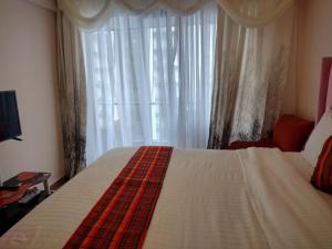 een slaapkamer met een bed en een groot raam bij Lenayan at Artesano in Nairobi +28 foto's