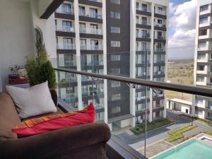 een balkon met een bank en uitzicht op een gebouw bij Lenayan at Artesano in Nairobi