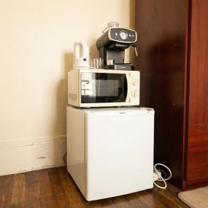 een magnetron bovenop een koelkast bij A spacious room in a strategic area in Montrouge