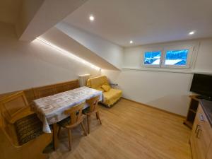 un piccolo soggiorno con tavolo e divano di Villa Flora by AMA Val di Fassa a Canazei