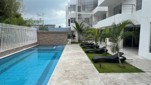 een zwembad met ligstoelen naast een gebouw bij Apartment in Same, Casa Blanca in Súa