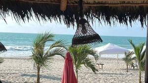 een strand met palmbomen en parasols en de oceaan bij Apartment in Same, Casa Blanca in Súa