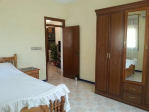 a bedroom with a bed and a wooden cabinet at Appartement bni bouayache in Aït Farts