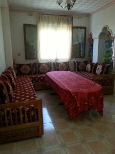 a living room with a red table and a couch at Appartement bni bouayache in Aït Farts