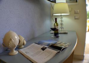 a table with a lamp and a book on it at Masseria Asciano in Ostuni