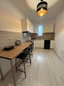 una grande cucina con tavolo e sedie in legno di Cleo Residence 5 Ghiroda a Ghiroda