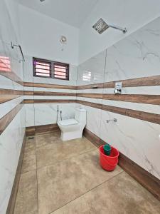 a bathroom with a toilet and a sink at RITHIKA HOMEs in Thekkady