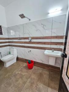 a bathroom with a toilet and a sink at RITHIKA HOMEs in Thekkady