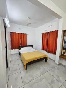 a bedroom with a bed and red curtains at RITHIKA HOMEs in Thekkady