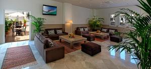 una sala de estar con sofás, mesas y plantas. en Hostal Tarifa, en Tarifa