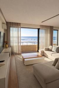ein Wohnzimmer mit Blick auf das Meer in der Unterkunft Beachouse Pvz - Seafront in Póvoa de Varzim