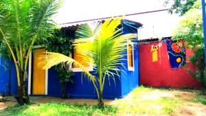 a colorful house with a palm tree in front of it at casa n 3 jeri in Jericoacoara +3 photos