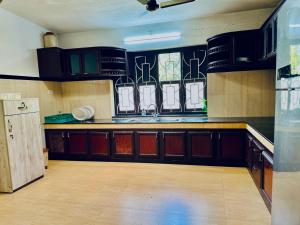 a kitchen with black cabinets and a counter top at HARSHAM Eco Village in Puthuppādi +8 photos