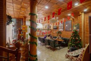 persone sedute a un tavolo in un ristorante con decorazioni natalizie di Dalat Note Hostel a Da Lat