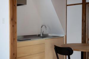 a kitchen with a sink and a wooden table at Rotan寺町 in Matsue +13 photos