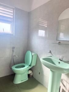 a bathroom with a toilet and a sink at Sunray Homes in Disagewatta
