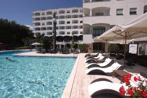 hotelowy basen z krzesłami i budynek w obiekcie Grand Hotel Don Juan w mieście Giulianova