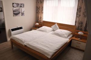 Schlafzimmer mit einem Bett mit weißer Bettwäsche und einem Fenster in der Unterkunft Effelder Bürgerstube in Effeld