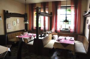 a dining room with two tables and two windows at Effelder Bürgerstube in Effeld