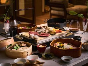 a table topped with different types of food and wine glasses at Glamday style hotel suite 山ノ麓 in Karuizawa