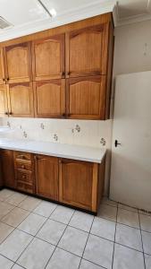 a kitchen with wooden cabinets and a white refrigerator at Griffin lakeside in Yarralumla
