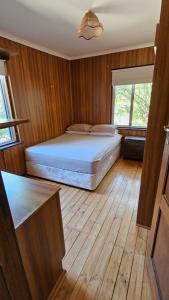 a bedroom with a bed with wooden floors and a window at Griffin lakeside in Yarralumla