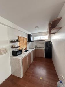 eine Küche mit weißen Wänden und einem schwarzen Kühlschrank in der Unterkunft High Land Pool Villas in Ko Tao