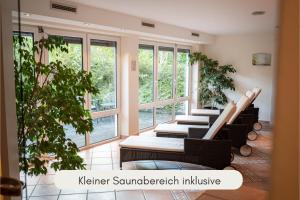 een rij stoelen in een kamer met ramen bij Hotel Filser in Füssen