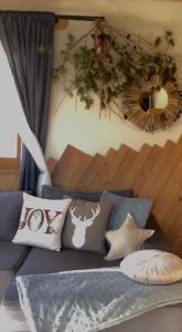 een woonkamer met een bank met kussens bij Domek Fox House z prywatna balią elektryczną na wyłączność in Kościelisko