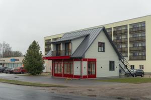 a house with a gambrel roof in front of a building at Good Home Apartment in Karksi-Nuia