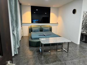 a bed in a room with a table and a couch at M-Resort Pathum-thani Thailand in Ban Khlong Sam Wa (3) +6 photos
