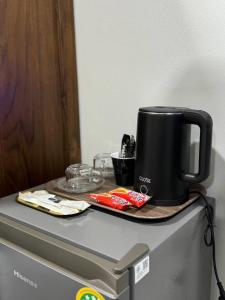 een zwarte koffiepot bovenop een koelkast bij M-Resort Pathum-thani Thailand in Ban Khlong Sam Wa (3)