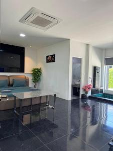 een woonkamer met een bank en een tafel bij M-Resort Pathum-thani Thailand in Ban Khlong Sam Wa (3)