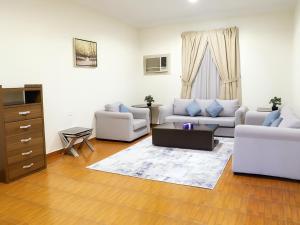 a living room with two couches and a table at المواســــــم الأربعة للشقق المخدومة in Tabuk