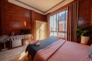 una camera da letto con un letto grande e una grande finestra di Dalat Note Hostel a Da Lat Altre 52 foto