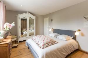 Le Domaine de Prune في Tour-en-Bessin: غرفة نوم بسرير كبير ومرآة كبيرة