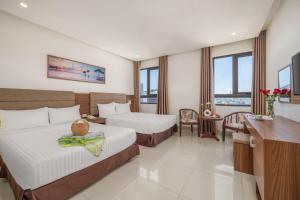 una camera d'albergo con due letti e una scrivania di Lumina Hotel & Apartment a Da Nang Altre 24 foto