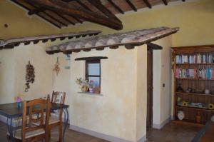 a dining room with a table and a book shelf at Bellavista in Seggiano