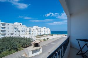 balcón con vistas a la playa y a los edificios en Résidence Sayadi - Chatt Meriam - Sousse, en Port El Kantaoui