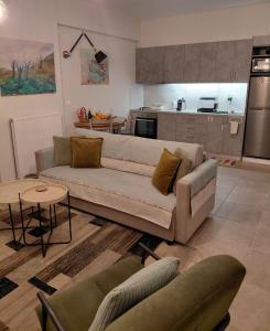 een woonkamer met een bank en een keuken bij Alpha 4 in Nafplio