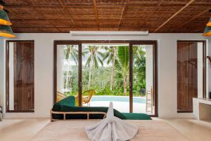 een woonkamer met een groene bank en een raam bij Woywoy Escape Bresela Adults Only in Tegalalang