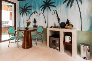 een eetkamer met een tafel en stoelen en palmbomen aan de muur bij Woywoy Escape Bresela Adults Only in Tegalalang