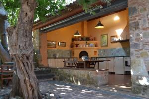 a kitchen and dining area with a tree in the foreground at Villa Daphnis & Chloe in Pyrgi Thermis