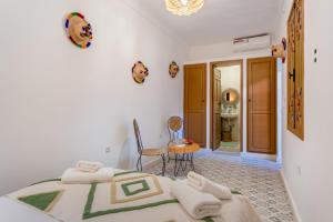 a bedroom with a bed and a table and a bathroom at Riad Cherifa Breakfast and Jacuzzi Terrace in Marrakesh +70 photos
