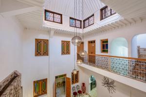 a staircase in a house with art on the walls at Riad Cherifa Breakfast and Jacuzzi Terrace in Marrakesh