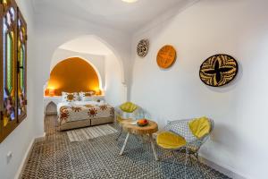 a bedroom with a bed and a table and chairs at Riad Cherifa Breakfast and Jacuzzi Terrace in Marrakesh