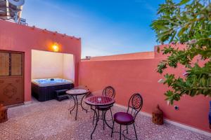 a patio with four chairs and a table and a tub at Riad Cherifa Breakfast and Jacuzzi Terrace in Marrakesh
