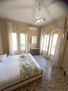 een slaapkamer met een groot bed met witte lakens en ramen bij Sperlonga Center Home in Sperlonga