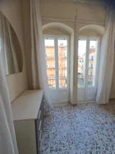 een kamer met 2 grote ramen en een kamer met een bureau bij Sperlonga Center Home in Sperlonga +75 foto's