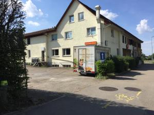 a building with a bus stop in front of it at Hostel Airport in Oberglatt